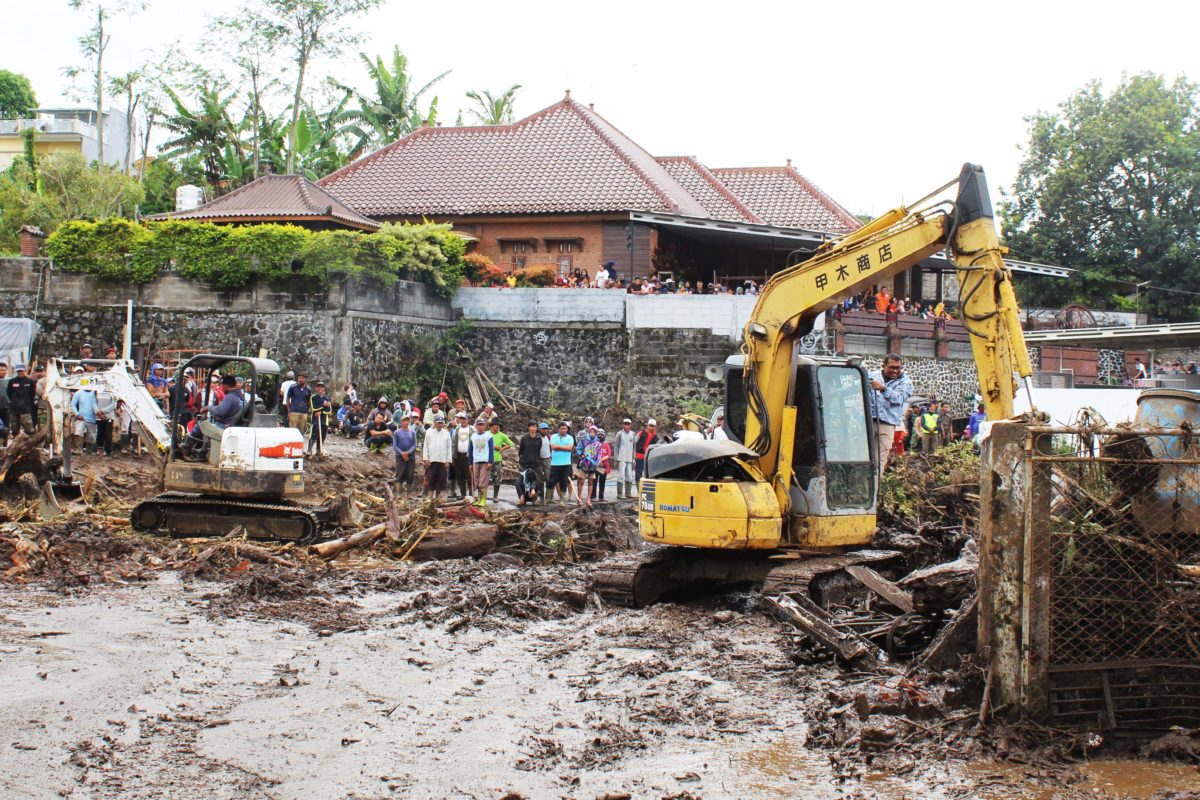 Escavator membersihkan material banjir mulai lumpur, batu dan kayu di Desa Bulukerto, Kecamatan Bumiaji, Kota Batu. (Foto: Eko Widianto)