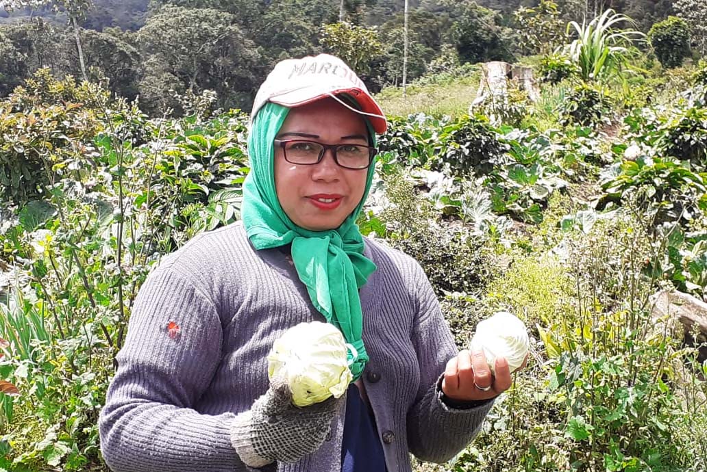 Petani memperlihatkan sayur hasil tanamnya di HKm Kibuk. Foto: Suryadi/ Mongabay Indonesia