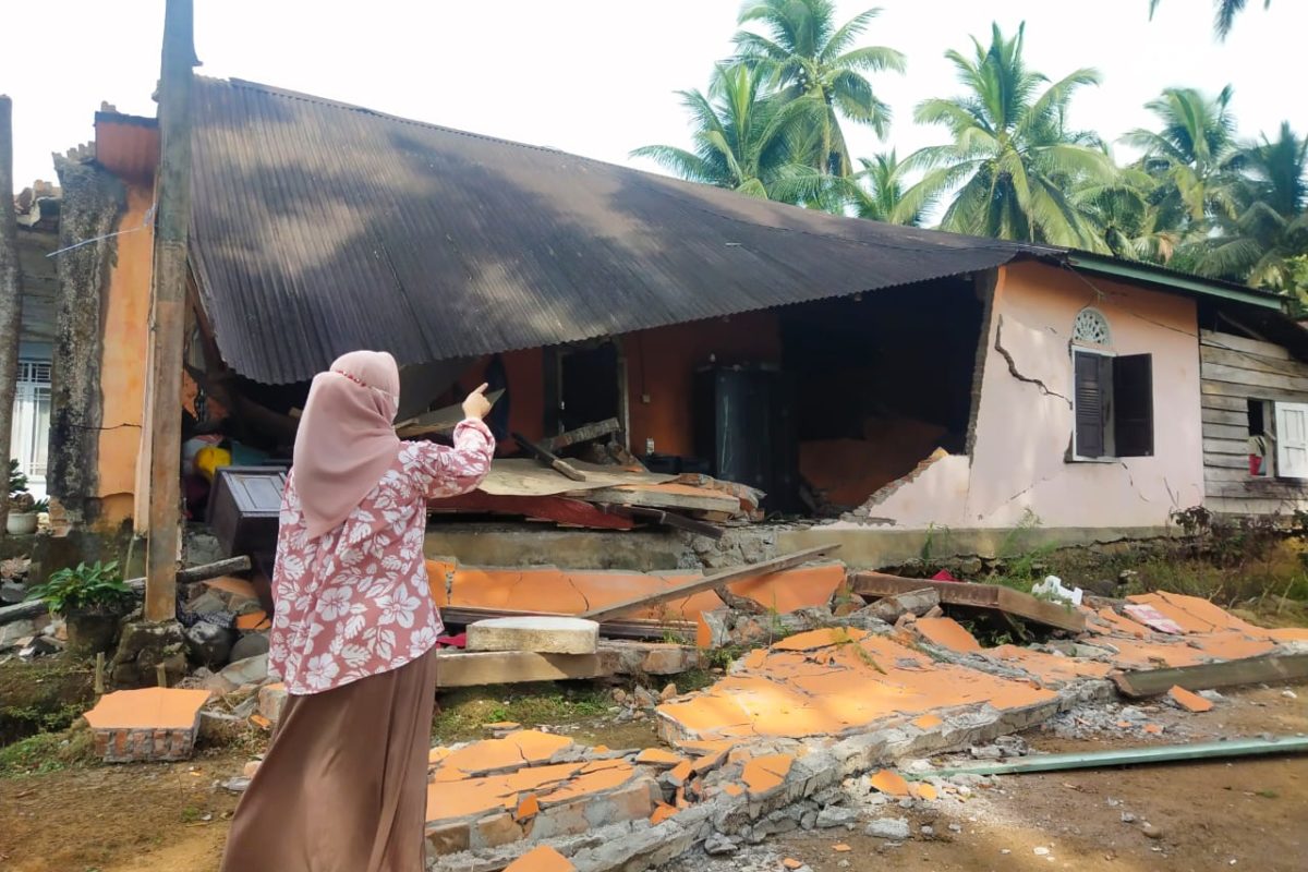 eorang perempuan menunjukkan rumahnya yang hancur akibat gempa bermagnitudo 6,1 di Kanagarian Kajai, kecamatan Talamau, Pasaman barat, jumat (25/2/22) sekitar pukul 8.39 WIB. Foto Vinolia/ Mongabay Indonesia