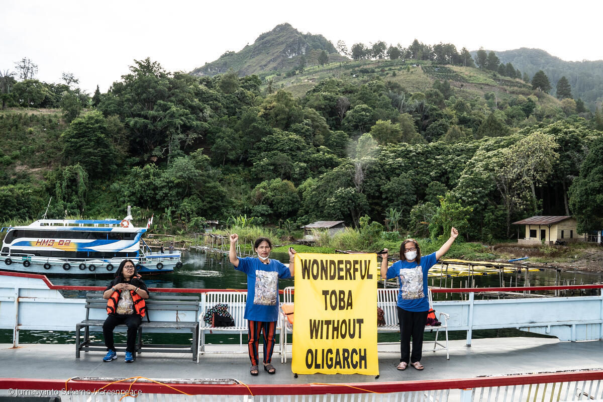 Aktivis perempuan memegang spanduk di dalam kapal ferry di Danau Toba. Mereka aksi di tengah berlangsung W20 Summit di Parapat. Foto: Greenpeace Indonesia