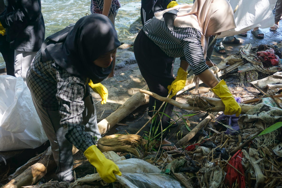 Para pemuda dan mahasiswa dari berbagai komunitas lingkungan membersihkan sampah plastik dan melakukan audit merek di Kali Metro, Merjosari, Kota Malang. (Foto: Komunitas Envigreen Society).