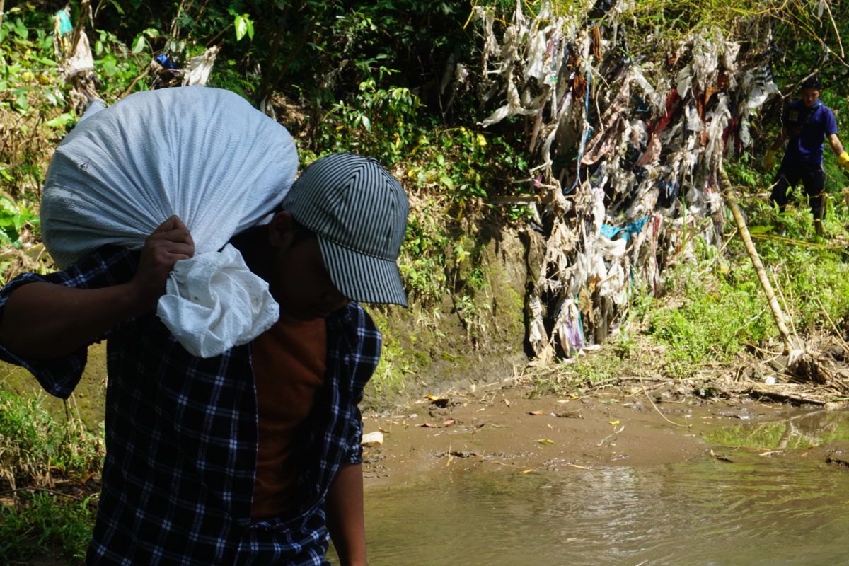 Para pemuda dan mahasiswa dari berbagai komunitas lingkungan membersihkan sampah plastik dan melakukan audit merek di Kali Metro, Merjosari, Kota Malang. (Foto: Komunitas Envigreen Society).