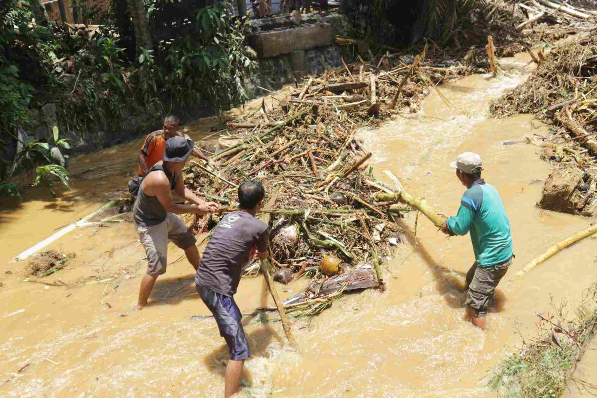 Sejumlah warga membersihkan tumpukan sampah kayu yang terbawa banjir bandang di Kabupaten Trenggalek. Foto: A. Asnawi/ Mongabay Indonesia