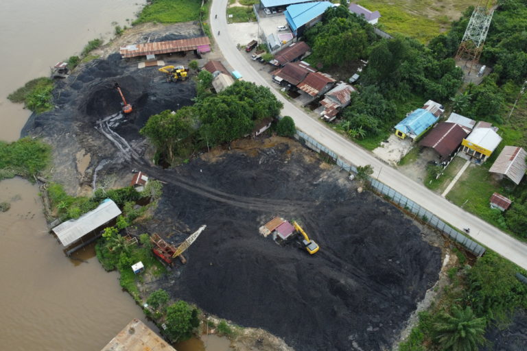 Tumpukan batubara ilegal berada di tepian sungai, yang berisiko mencemari perairan. Foto: Abdallah Naem/ Mongabay Indonesia