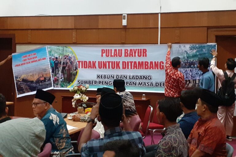 Masyarakat Pulau Bayur membentang spanduk di tengah rapat bersama Komisi I DPRD Riau, membahas penolakan operasi tambang batu bara, Senin 26 Juni 2023. Foto Suryadi.jpg